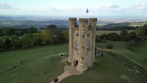 Low-aerial-orbit-shot-of-Broadway-tower,-an-English-landmark-stood-atop-Beacon-Hill-in-the-Cotswolds,-UK