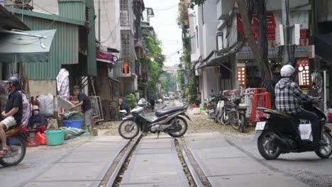 Busy-Train-Street-with-motorcycles-and-traffic-in-famous-Old-Quarter-in-Hanoi,-Vietnam