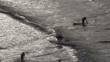 Slowmotion-of-Surfers-practicing-on-small-waves-shot-in-silhouette