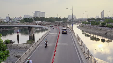 Aerial-view-of-traffic-crossing-city-bridge,-car-and-motorbike-moving-on-the-bridge