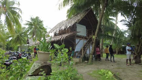 A-dynamic-handheld-shot-of-a-two-story-hut-made-out-of-nipa-and-local-lumber