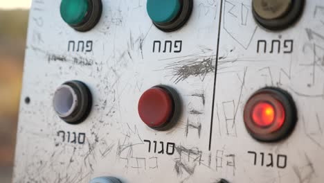 press-push-button-on-control-panel-with-Hebrew-text-beneath,-close-up
