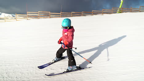 Young-girl-learning-to-ski-slowly-descending-flat-empty-slope