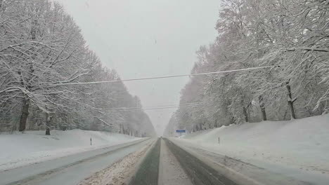 Car-road-trip-cruising-through-the-idyllic-snow-covered-countryside-and-woods