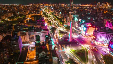 Lufthyperlapse-über-Dem-Obelisken-Von-Buenos-Aires,-Argentinien,-Nacht-In-Der-Avenida-9-De-Julio-Und-Im-Stadtzentrum,-Lebendige-Lichter-Und-Farben,-Städtischer-Transport-In-Bewegung