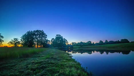 sun-rising-over-a-beautiful-pond-and-cottage-in-a-village-time-lapse