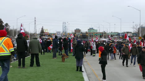 Protesters-against-covid-vaccine-mandate-waving-canadian-flags,-on-a-cold-cloudy-day