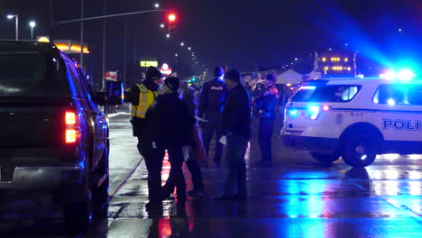 Nachtaufnahme-Einer-Verkehrskontrolle-Der-Polizei-Während-Eines-Freiheitskonvois-In-Kanada,-Polizeifahrzeuge-Mit-Blinkenden-Lichtern
