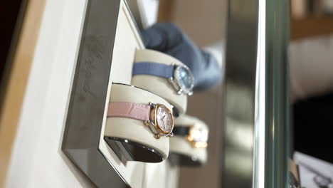 Closeup-vertical-video-showcasing-Chopard-watches-being-picked-by-shop-assistant