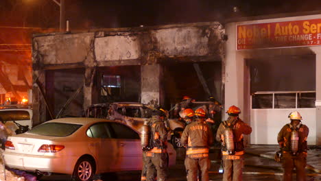 Firefighters-fighting-burning-commercial-building-flames-in-Toronto,-back-view