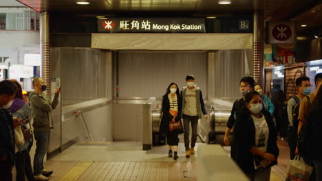 People-walking-outside-of-the-Mong-Kok-Station-at-night-in-Hong-Kong