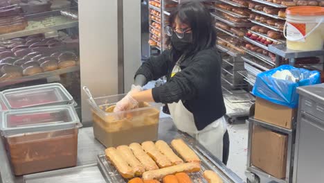 Woman-preparing-pastry-cakes-and-donuts-with-icing,-Grand-Central-Market,-Downtown-Los-Angeles