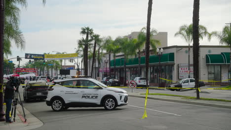 A-Police-Car-and-Camerman-Behind-Caution-Tape-After-the-Mass-Shooting