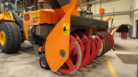 Airport-Snow-Cleaning-Equipment-in-Hangar,-Bulldozer-with-Rotary-Blades-Machinery