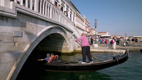 Turistas-En-Góndola-Pasando-Bajo-El-Ponte-Della-Paglia-En-Venecia,-Italia