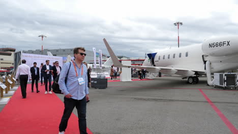 Guests-of-European-Business-Aviation-Exhibition,-walking-by-private-jet-aircraft