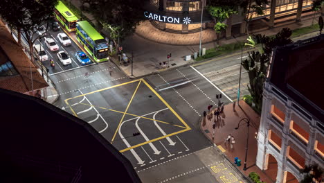 Night-time-lapse-of-intersection-by-Carlton-Hotel,-Raffles-City-Mall,-Singapore