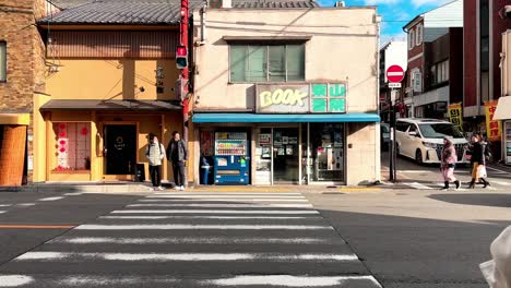 Two-Young-Asian-Male-Waiting-at-Zebra-Crossing,-Kyoto,-Japan