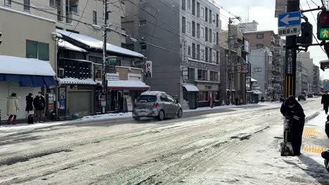Zwei-Männliche-Arbeiter-Schaufeln-Schnee-Auf-Der-Straße-In-Kyoto,-Japan
