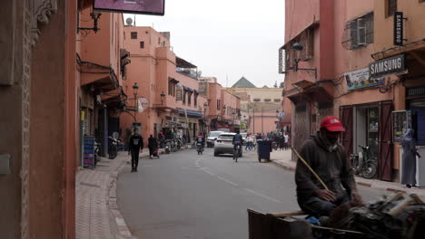 Street-view-of-locals-commuting-in-Marrakesh---donkey-cart,-bicycle,-scooter