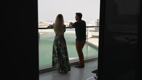 Traveling-Couple-Admiring-View-From-The-Balcony-Of-A-Hotel-In-Abu-Dhabi,-UAE