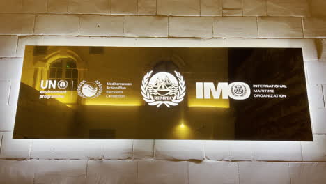 United-Nations,-Mediterranean-Convention,-International-Maritime-Organization-LOGOS-on-a-limestone-wall