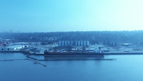 cargo-ship-loading-raw-grain-drone-flyover-clear-calm-day-silos-being-loaded-onto-ship
