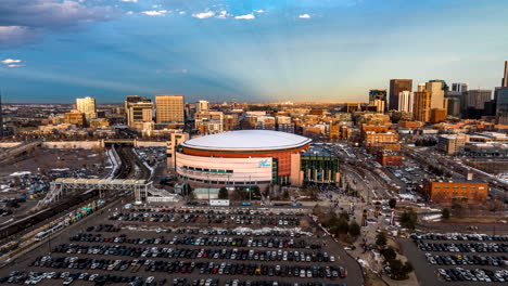 Aerial-hyperlapse-of-cars-parking-and-droves-of-people-filing-into-Ball-Arena-to-attend-a-sporting-event-in-Denver,-Colorado