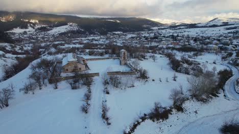 Orthodox-church-on-the-hill-covered-by-snow-near-Voskopoja-village-in-Albania,-religion-spot
