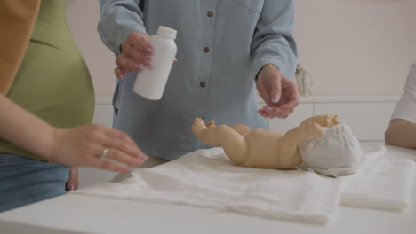 Teacher-and-student-putting-baby-powder-on-toy-baby