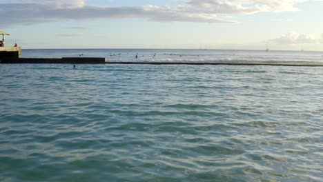 Tilt-up-reveal-of-waikiki-walls-breakwater-as-wave-crashes-over-wall