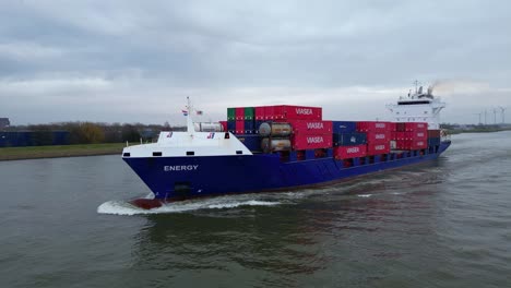 Aerial-Off-Port-Side-Of-Energy-Cargo-Ship-Carrying-Viasea-Intermodal-Containers-Navigating-Along-Oude-Maas