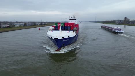 Aerial-Parallax-Shot-Around-Forward-Bow-Of-Energy-Cargo-Ship-Carrying-Viasea-Intermodal-Containers-Passing-Along-Oude-Maas