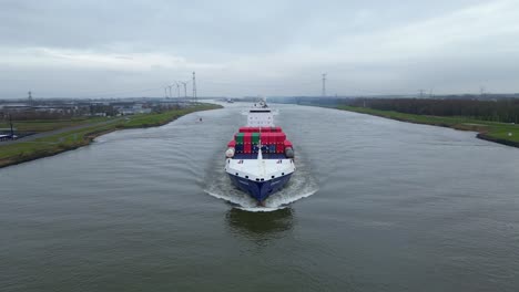 Aerial-Tracking-Shot-Off-Forward-Bow-Of-Energy-Cargo-Ship-Carrying-Viasea-Intermodal-Containers-Navigating-Along-Oude-Maas