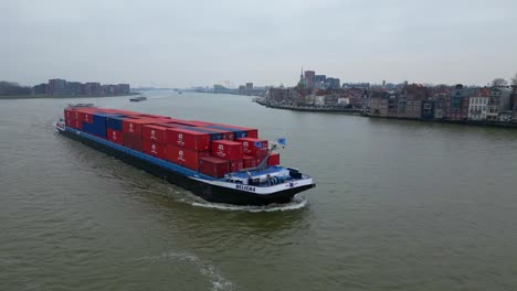 Aerial-View-Of-Belicha-Inland-Freighter-Transporting-Intermodal-Containers-Sailing-Along-Oude-Maas-Through-Dordrecht