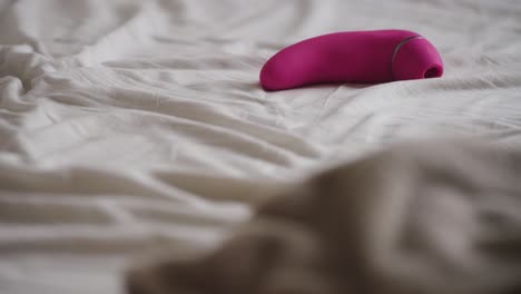 Rack-focus-from-grey-sheets-to-pink-vibrator-on-bed-sheets