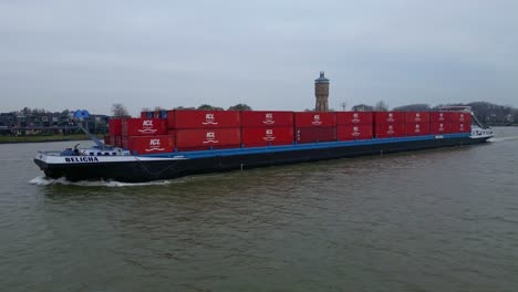 Aerial-Tracking-Shot-Off-Port-Side-Of-Belicha-Inland-Freighter-Transporting-Intermodal-Containers-Along-Oude-Maas