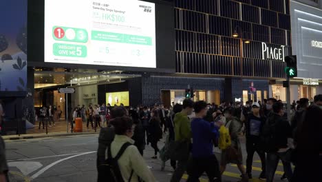 8-February-2023---Night-time-View-Of-Pedestrians-Crossing-Canton-Road-In-Tsim-Sha-Tsui,-Hong-Kong