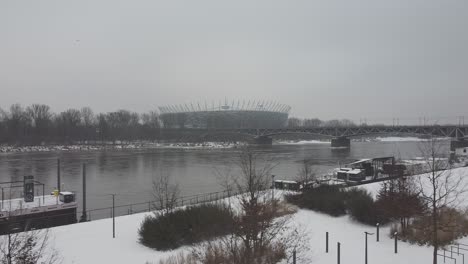 Drone-video-of-warsaw-national-stadium-on-a-snowy-day-above-Vistula-river