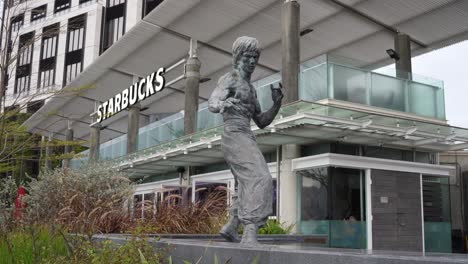 Bruce-Lee-Statue-Auf-Der-Avenue-Of-Stars-In-Hongkong,-Starbucks-Café-Im-Hintergrund