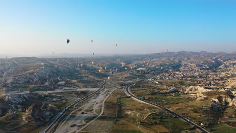 Rotating-epic-cinematic-drone-shot-above-Cappadocia-looking-up-at-the-multiple-hot-air-balloons-in-Turkey