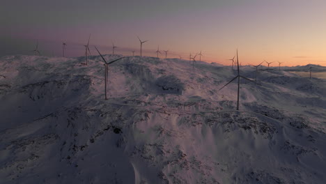 Wind-turbines-on-snowy-mountains-in-arctic-at-sunset-in-Norway