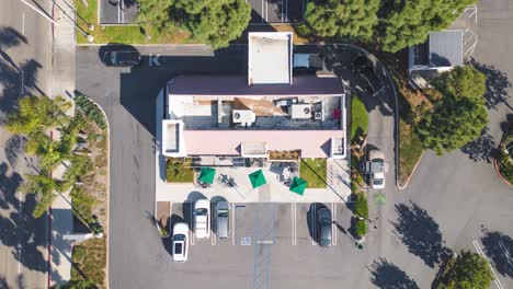 top-down-aerial-time-lapse-shows-Starbucks-customers-enjoying-a-bright-SoCal-day,-going-in-out,-driving-through-the-drive-thru