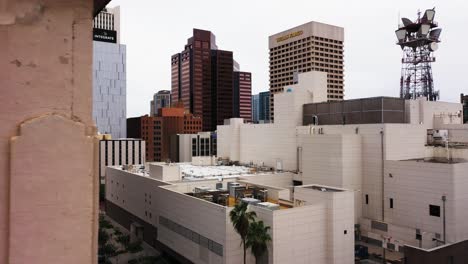 Aerial-view-of-a-radio-tower-blending-in-with-the-downtown-skyscrapers-in-Phoenix,-Arizona