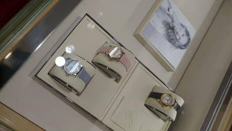 Vertikale-Rotation-In-Zeitlupe-über-Einer-Sammlung-Luxuriöser-Chopard-Uhren-Im-Ladendisplay