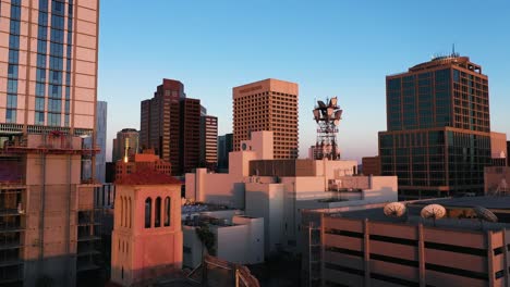Drone-shot-meandering-through-Phoenix,-Arizona's-downtown-skyscrapers-at-sunset