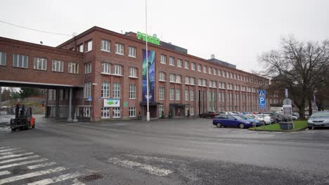 Tire-factory-of-Nokian-Tyres,-Nokian-Renkaat,-and-cars-parked-in-front-of-it-in-Nokia,-Finland