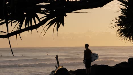 Surfista-Esperando-Entrar-Al-Océano-Al-Amanecer-En-Burleigh-Heads,-Gold-Coast,-Queensland,-Australia