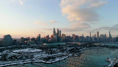Aerial-view-approaching-the-Solider-field-Stadium-and-the-Chicago-skyline,-winter-sunset-in-Illinois,-USA