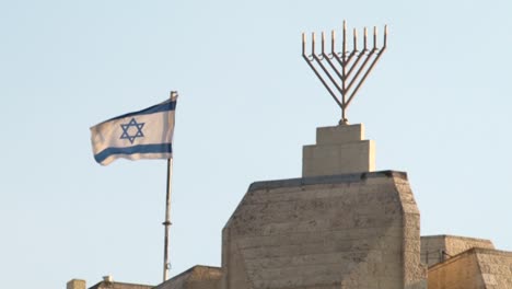 Israeli-national-flag-waving-in-the-wind-next-to-large-hanukkah